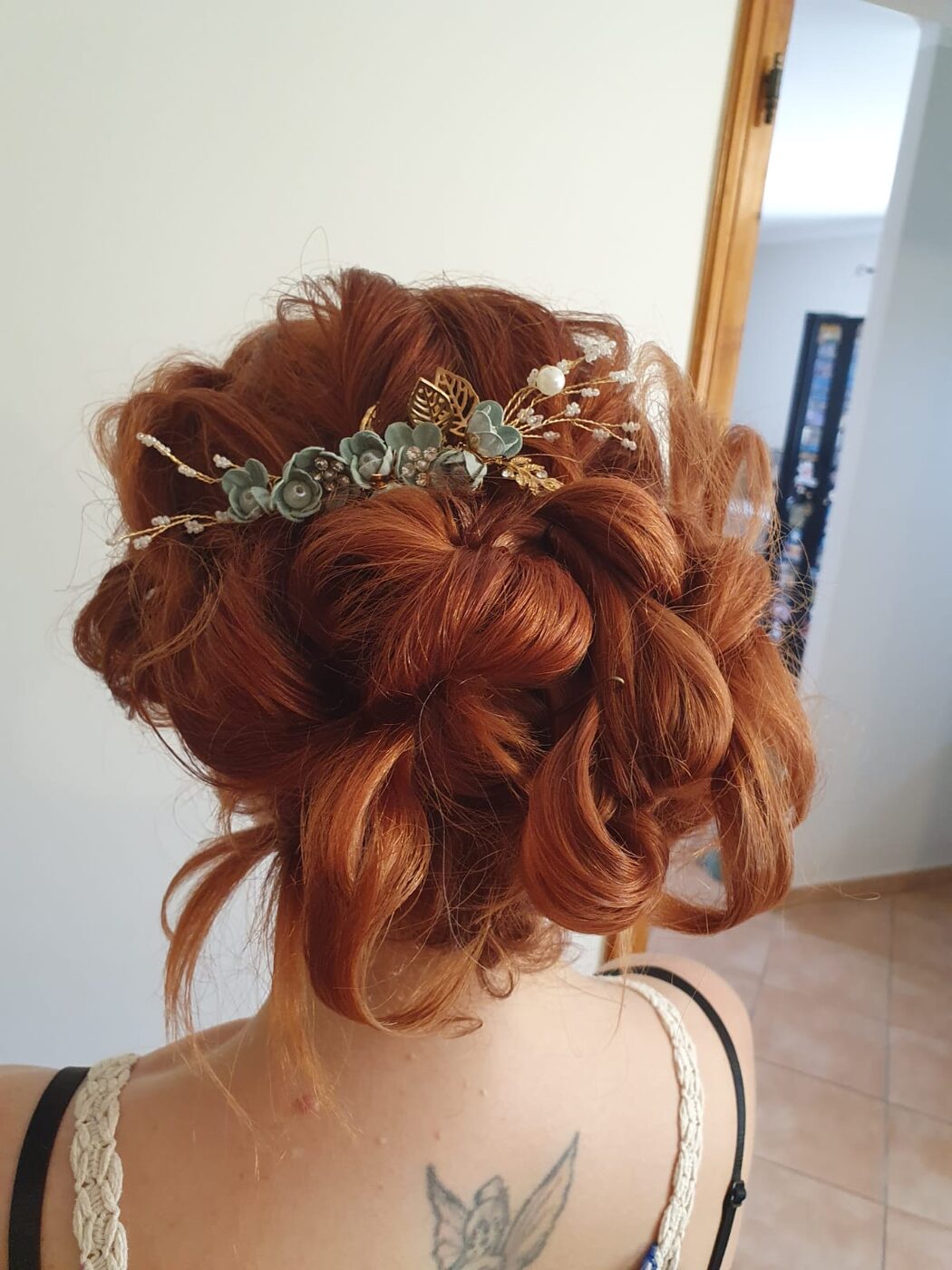 Chignon roux cuivré avec accessoires dorés et eucalyptus